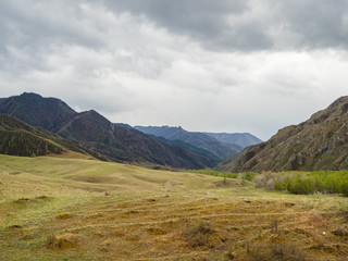 Dramatic clouds in the sky over the steppe and mountain peaks in the Altai, Russia