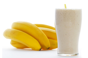 Glass of Banana Shake and Yellow Bananas in Isolated White Backdrop