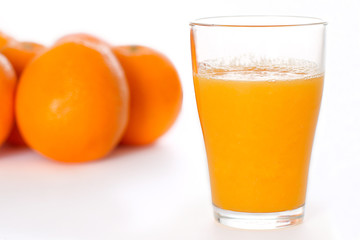 Glass of Fresh Orange Juice and Oranges on Isolated White Backdrop