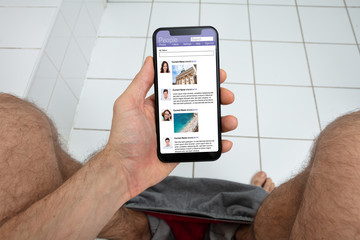 Man Using Cellphone In Toilet