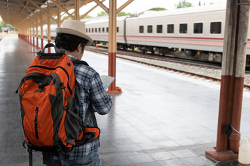 Fototapeta na wymiar Asian traveler man with belongings waiting for travel by train at Chiang Mai train station, Thailand