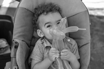 baby playing with balloon black and white