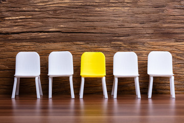 Empty Small Chair In Row On Wooden Background