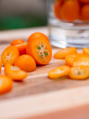 Kumquat slices cut on wooden board 