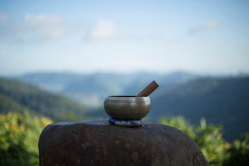 Tibetan singing bowl with sanskrit engraving pattern and sticks on the rock. .(The Nepal word on...