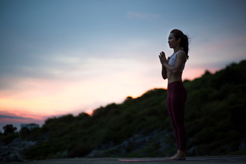 Side view of healthy women practicing yoga. standing in mountain exercise, Tadasana pose,.   .beautiful landscape view sky on evening, concept for exercising, health care