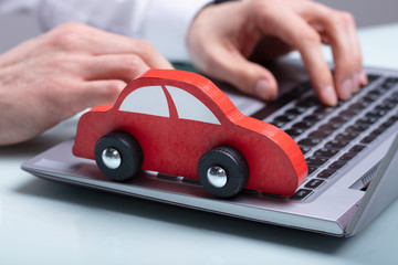 Small Red Car On Laptop Keypad