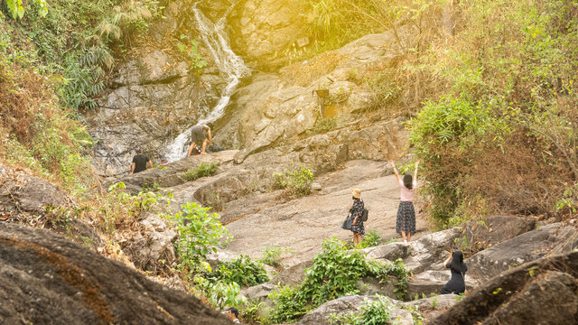 People are immersed in cold water to cool off at Huay Kaew Waterfall in Chiang Mai, Thailand.