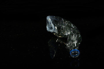 Discarded plastic water bottle isolated on black background