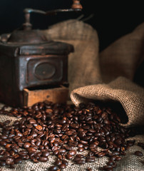coffee beans and vintage coffee grinder. Roasted coffee beans in a vintage setting. Dark still life...