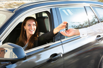 Woman Giving Car Key To Male Hand