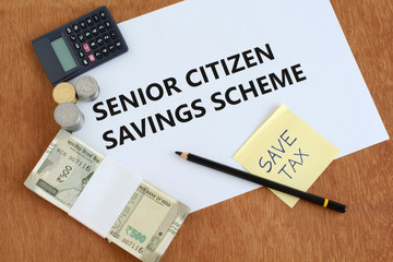 Senior citizen savings scheme, an investment avenue for Indian citizens of age 60 and above, concept highlighted through text, Indian rupees and coins, a save-tax note, calculator and pencil.