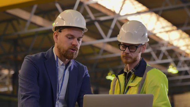 Portrait of industrial worker talking to supervisor