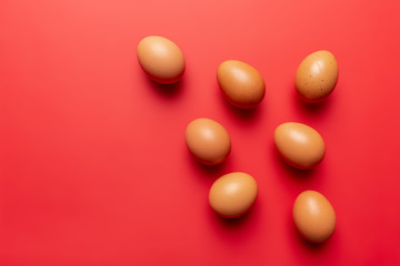 Fototapeta na wymiar brown eggs on red background