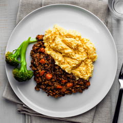 Delicious shepherd’s pie made of smashed potatoes, minced meat, lentil and vegetables and prepared in a slow cooker. Close-up shot. Top view, above shot.