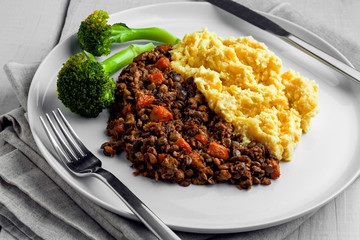 Shepherd’s pie on a plate. Delicious meat pie made of smashed potatoes, minced meat, lentil and vegetables.