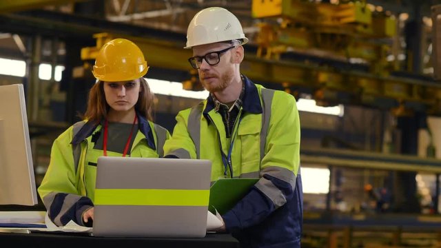 Male and Female Industrial Engineers in Hard Hats