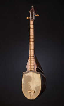 ancient Asian stringed musical instrument on black background with backlight