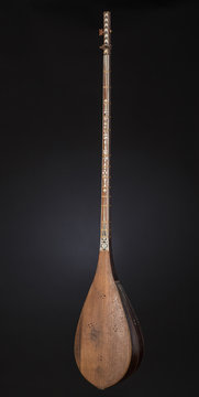 ancient Asian stringed musical instrument on black background with backlight