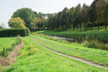 Fototapeta na wymiar hiking path, meadow and dike in fortified city Elburg, The Netherlands 