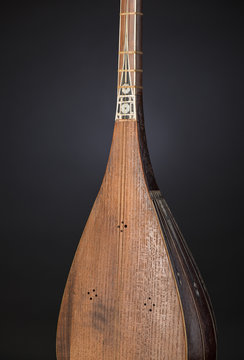 part ancient Asian stringed musical instrument on black background with backlight