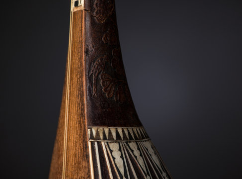 part ancient Asian stringed musical instrument on black background with backlight