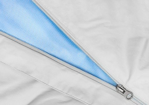 Open zipper on a gray jacket with a bright blue lining.