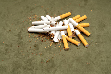 Exemption from smoking. A lot of broken cigarettes on a green background