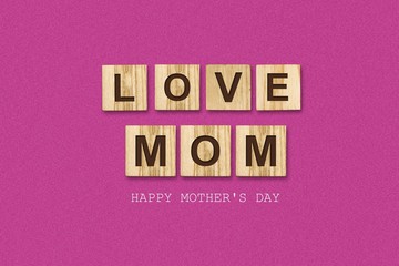 Happy Mother's Day background. Inscription, Love Mom, on wooden blocks. Pink background. Congratulatory background.
