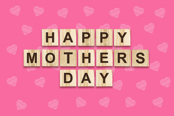 Happy Mother's Day, word written on wooden blocks. Pink background. Congratulatory background. Holiday Card.