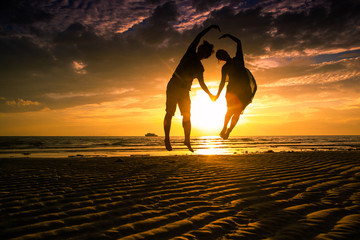 Couple lover make hand lover on the sunset beach