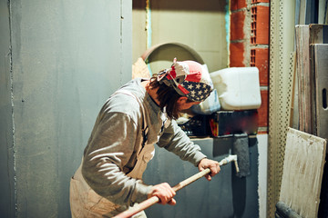 Painter painting walls with a extender roller indoors.