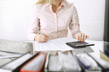 Bookkeeper woman or financial inspector  making report, calculating or checking balance, close-up.  Business, audit or tax concepts