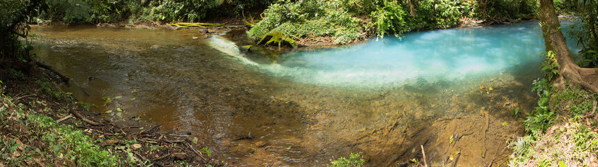 Forming of sky-blue water at the junction of Rio Buenavista and Quebrada Agria at Tenidero on Rio Celeste in Parque Nacional Volcan Tenorio in Costa Rica