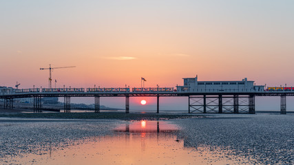 Obraz premium Dawn With Sun Rising Behind Worthing Pier at Low Tide