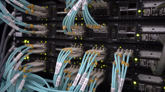 Fiber Optical Cables close up on Datacenter. Telecommunication Broadband. Blink Green Led Lights. Technology server concept.