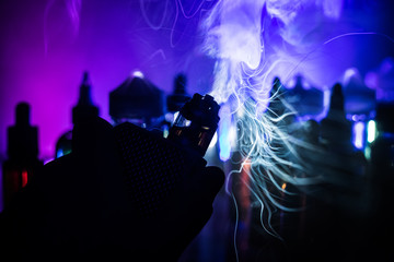 Fototapeta na wymiar Vape concept. Electronic Cigarette vape explosion. Smoke clouds and vape liquid bottles on dark background. Light effects. Useful as vape advertisement.