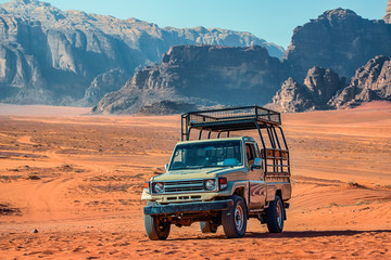 .old Japanes jeep in front of incredible lunar landscape in Wadi Rum in the Jordanian desert . Wadi Rum also known as The Valley of the Moon,  Jordan - Image - obrazy, fototapety, plakaty