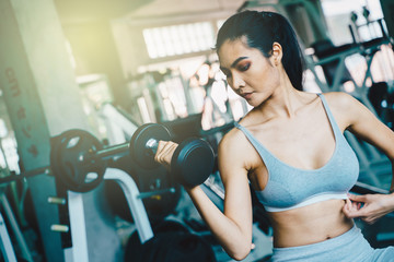 Fototapeta premium Wellbeing smart asian sport women lifting dumbbell in gym