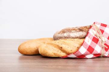 Fresh baguettes with red napkin on wooden table
