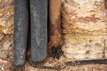 Fototapeta premium Insulation made of rubber cable and rusty metal pipe