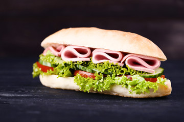 Tasty sandwich on black wooden table