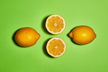 Lemon on green background. Flat lay, top view, copy space . Food concept.