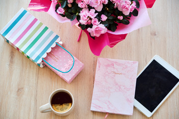 Overhead flatlay of cozy workspace with beautiful pink flowers