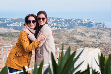 Naklejka premium Two cute female friends smiling and hugging