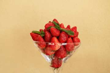 Red strawberry with mint on a yellow background. Delicious, juicy, sweet, fresh berry. 