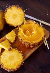 Splash fresh fruit juice with exotic pineapple on a wooden brown table. A composition made of ananas. Top wiev. 