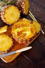 Splash fresh fruit juice with exotic pineapple on a wooden brown table. A composition made of ananas. Top wiev. 
