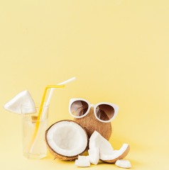 Fresh Coconut cocktail with a straws on yellow background, copy space