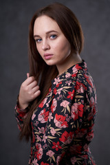 Portrait of a female in a colored dress on gray background